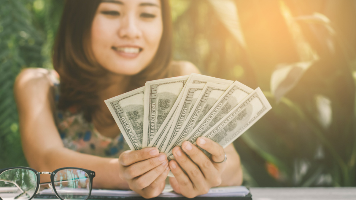 Young happy woman with lots of money from working business.
